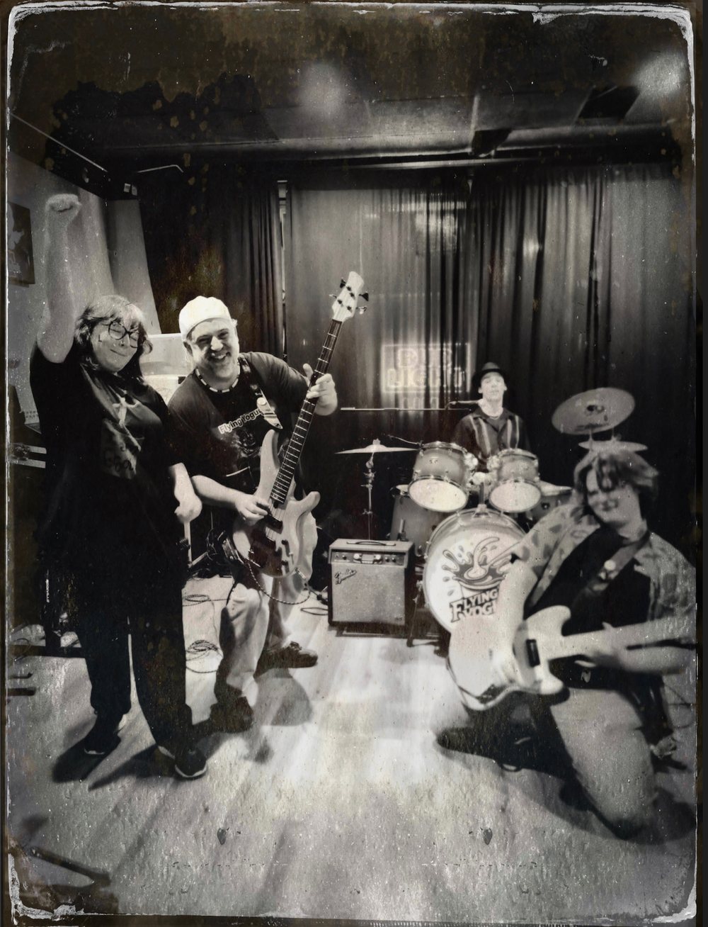 Flying Yogurt band members posing with their instruments in the rehearsal studio